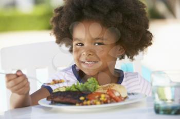 Royalty Free Photo of a Little Girl Eating Outside