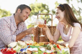 Royalty Free Photo of a Couple Eating Outside and Toasting With Wine