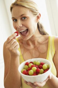 Royalty Free Photo of a Woman Eating Fresh Fruit
