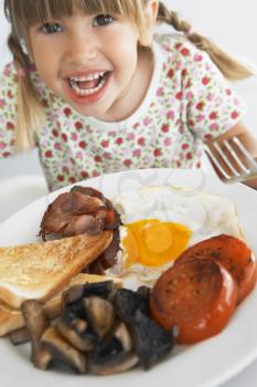 Royalty Free Photo of a Little Girl Eating Bacon and Eggs