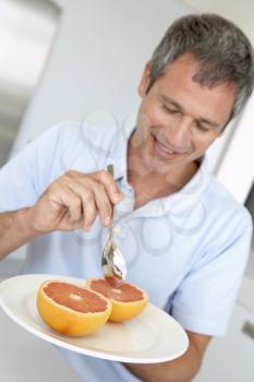 Royalty Free Photo of a Man Eating Grapefruit