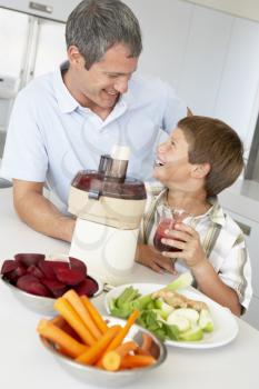Royalty Free Photo of a Father and Son Making Vegetable Juice