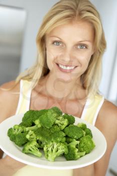 Royalty Free Photo of a Woman With a Plate of Broccoli
