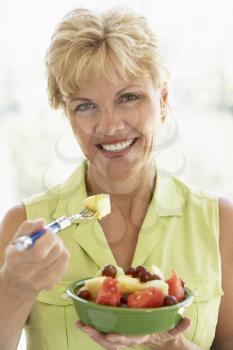 Royalty Free Photo of a Woman Eating Fruit Salad