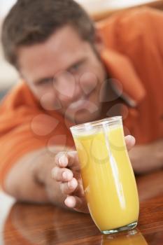 Royalty Free Photo of a Man Reaching for a Glass of Orange Juice