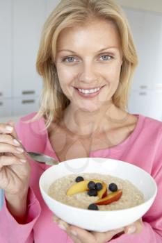 Royalty Free Photo of a Woman Eating Oatmeal With Fresh Fruit