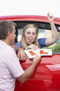 Royalty Free Photo of a Girl Receiving Her Learner's Plates