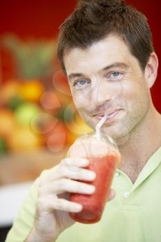Royalty Free Photo of a Man Drinking a Berry Smoothie