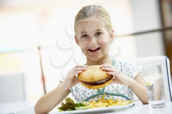 Royalty Free Photo of a Girl Eating a Big Burger at a Mall