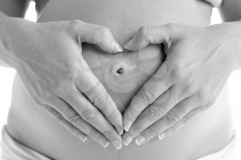 Royalty Free Photo of a Pregnant Woman Forming a Heart on Her Belly