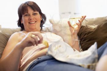 Royalty Free Photo of a Woman Eating Chips and Drinking Wine