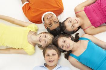 Royalty Free Photo of a Group of Children on the Floor With Their Heads Together