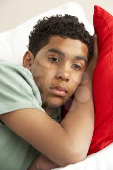 Royalty Free Photo of a Young Boy With His Head on a Pillow
