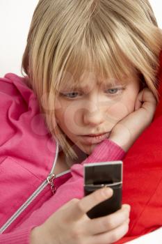 Royalty Free Photo of a Girl Reading a Text and Looking Worried