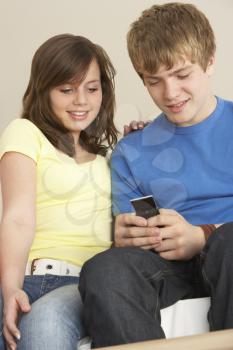 Royalty Free Photo of a Teenage Couple Reading a Text Message