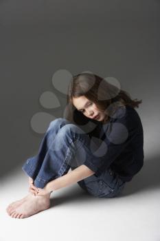 Royalty Free Photo of a Girl Sitting on the Floor