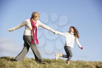 Royalty Free Photo of a Woman and Her Granddaughter Running Outside