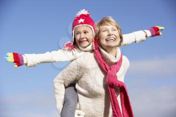 Royalty Free Photo of a Grandmother Giving Her Granddaughter a Piggyback Ride