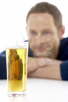Royalty Free Photo of a Man Looking at a Glass of Beer