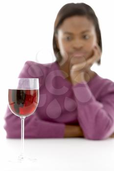 Royalty Free Photo of a Woman Looking at a Glass of Wine