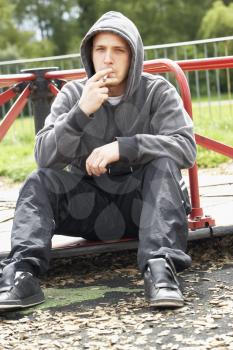 Royalty Free Photo of a Guy Smoking a Joint in a Playground