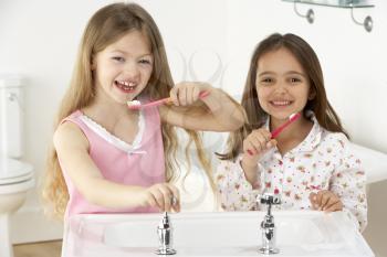 Royalty Free Photo of Two Girls Brushing Their Teeth