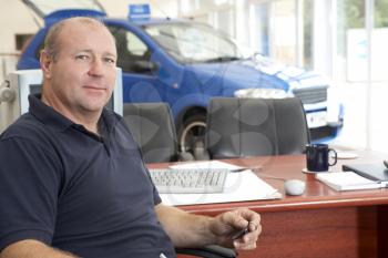 Royalty Free Photo of a Car Salesman in the Showroom