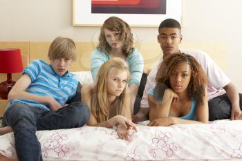 Royalty Free Photo of a Group of Teens on a Bed
