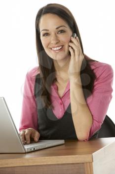 Royalty Free Photo of a Woman at a Laptop With a Cellphone