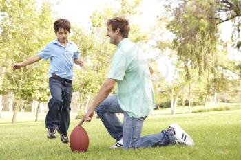 Royalty Free Photo of a Father and Son Playing Football
