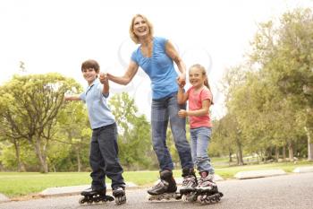 Royalty Free Photo of a Woman Skating With Her Grandchildren