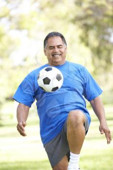 Royalty Free Photo of a Man Bouncing a Soccer Ball on His Knee