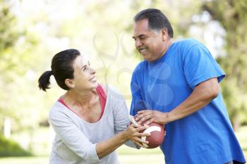 Royalty Free Photo of a Couple Fighting Over a Football