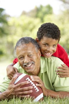 Grandfather With Grandson In Park With American Football