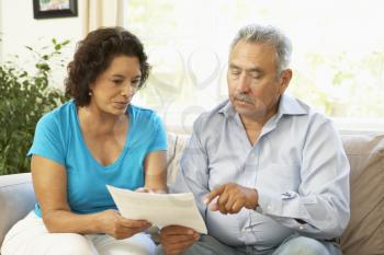 Senior Couple Studying Financial Document At Home