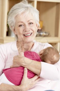 Grandmother Cuddling Granddaughter At Home