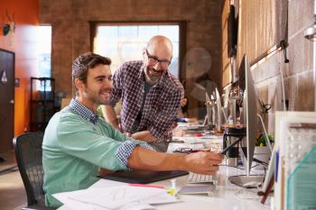 Designers Working Together At Desks In Modern Office