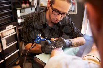 Tattoo Artist Working On Design For Male Client