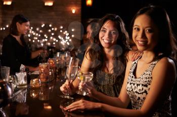 Portrait Of Female Friends On Night Out At Cocktail Bar