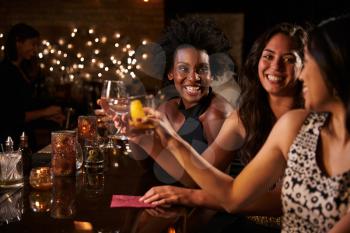Female Friends Enjoying Night Out At Cocktail Bar