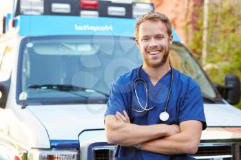 Portrait Of Male Doctor Standing In Front Of Ambulance