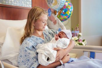 Teenage Girl Holding Newborn Baby Son In Hospital