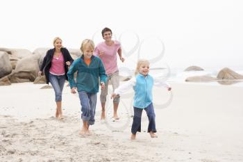 Young Family Running Along Winter Beach