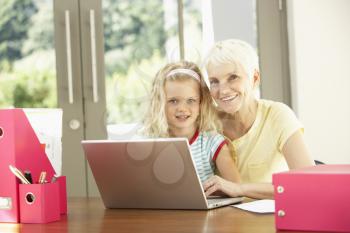 Granddaughter And Grandmother Using Laptop At Home