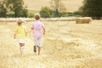 Children Running Through Summer Harvested Field