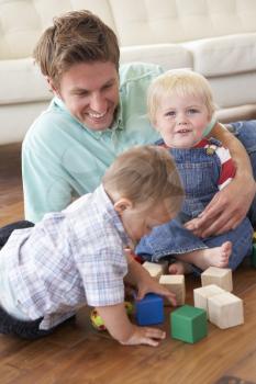 Father And Sons Playing With Coloured Blocks At Home