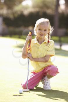 Young Girl Practising Golf On Putting On Green