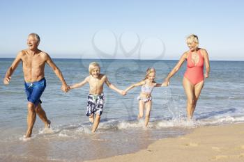 Grandparents With Grandchildren Enjoying Beach Holiday Together