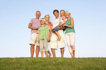 A family, with parents, children and grandparents, posing in a field