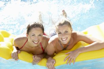 Two women friends having fun together in pool